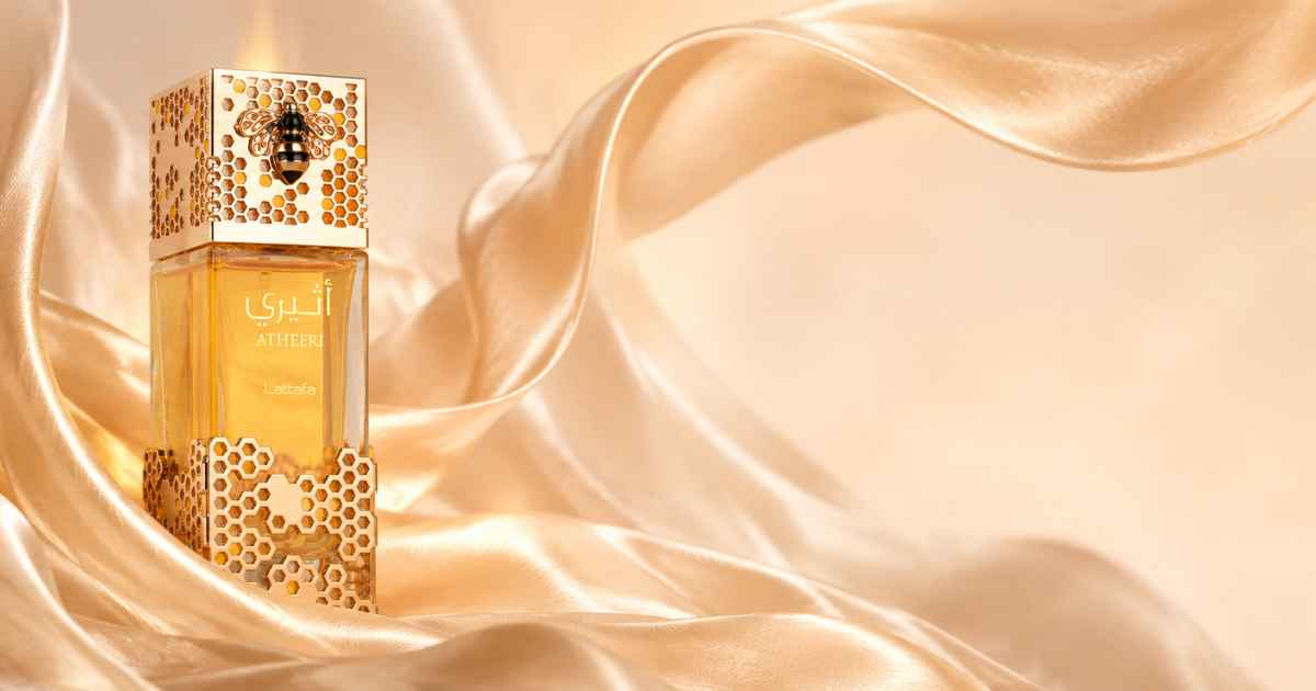 Frasco original do perfume árabe Atheeri sobre tecido de seda dourada